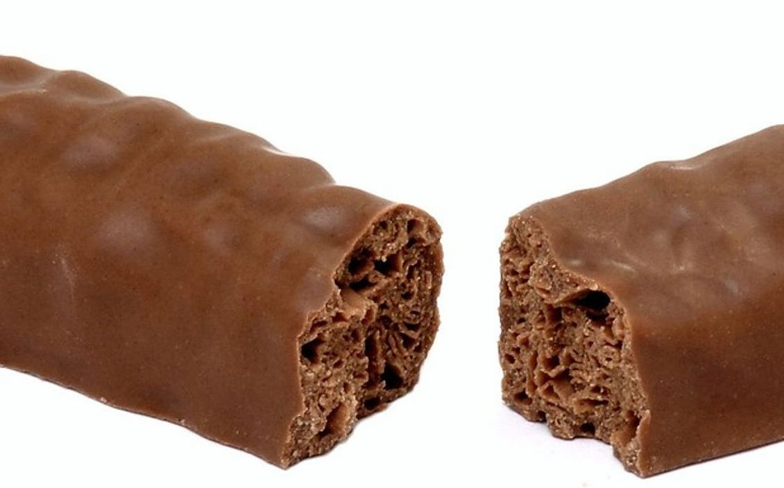 A salted caramel chocolate bonbon on a dish, still glossy from tempering